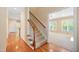 Hallway with hardwood floors and a staircase leading to an open room, offering a glimpse of the home's layout at 306 Neuse Ridge Dr, Clayton, NC 27527