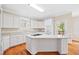 Well-lit kitchen with white cabinets, granite countertops, hardwood floors, and stainless steel appliances at 306 Neuse Ridge Dr, Clayton, NC 27527