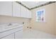 Bright laundry room with ample storage space and a white sink at 306 Neuse Ridge Dr, Clayton, NC 27527