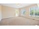 Bright, carpeted living room with large windows and an open doorway to the rest of the house at 306 Neuse Ridge Dr, Clayton, NC 27527