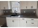 Modern kitchen with white cabinets, gray countertops, and a stylish backsplash at 415 Sowell St, Durham, NC 27701