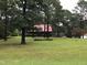 Brick home with red metal roof, large yard, and mature trees at 515 Docs Rd, Lillington, NC 27546