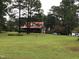 Brick home with red metal roof, large yard, and mature trees at 515 Docs Rd, Lillington, NC 27546