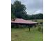 Red metal roof outbuilding with a grassy yard at 515 Docs Rd, Lillington, NC 27546