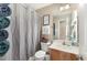 Neutral bathroom featuring a vanity, toilet, and shower with gray curtain at 575 Crystal Spring Dr, Sanford, NC 27332