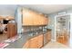 Kitchen featuring stainless steel dishwasher, tile backsplash, and view into a bright dining area at 575 Crystal Spring Dr, Sanford, NC 27332