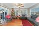 Inviting living room with hardwood floors, a Christmas tree, large windows, and a comfortable gray sofa at 575 Crystal Spring Dr, Sanford, NC 27332