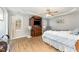 Bright main bedroom featuring wood floors, tray ceiling, and a sitting area near the window at 575 Crystal Spring Dr, Sanford, NC 27332