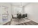 Bright dining area with glass table and four gray chairs at 5940 Illuminate Ave, Raleigh, NC 27616