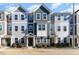 Three-story townhouses with gray siding, stone accents, and landscaping at 5940 Illuminate Ave, Raleigh, NC 27616