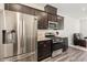 Stainless steel appliances and dark brown cabinetry in this kitchen at 5940 Illuminate Ave, Raleigh, NC 27616