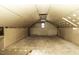 Unfinished attic with plywood floors, open rafters, and a small window for natural light at 805 Joshua Clay Dr, Rocky Mount, NC 27803