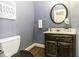 Powder room with hardwood flooring, toilet, sink and mirror, with decorative wallpaper at 805 Joshua Clay Dr, Rocky Mount, NC 27803