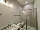 Bathroom with tiled walk-in shower, glass door, and marble countertop sink at 90 Firefly Ln, Louisburg, NC 27549