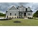 Beautiful two-story home with a manicured lawn and a welcoming brick and gray facade, exuding curb appeal at 90 Firefly Ln, Louisburg, NC 27549