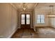 Spacious foyer featuring elegant lighting fixtures and large double doors, creating a grand entrance at 90 Firefly Ln, Louisburg, NC 27549