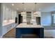 Modern kitchen with a large island, white cabinets, and stainless steel appliances, perfect for culinary enthusiasts at 90 Firefly Ln, Louisburg, NC 27549