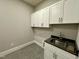 Laundry room featuring stainless steel sink and white cabinets for storage at 90 Firefly Ln, Louisburg, NC 27549