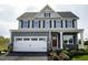 Two-story house with gray siding, white garage door, and landscaping at 1020 Country Pasture Cv, Wendell, NC 27591