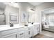 Bathroom featuring double sinks with sleek black hardware, white cabinetry, and modern lighting at 1024 Country Pasture Cv, Wendell, NC 27591