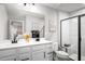 A modern bathroom with double vanity, large mirror, and glass-enclosed shower at 1024 Country Pasture Cv, Wendell, NC 27591