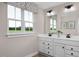 Bright bathroom featuring a double sink vanity, framed mirror, and a large window with a green outdoor view at 1024 Country Pasture Cv, Wendell, NC 27591
