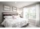 Bright bedroom featuring a queen-sized bed and a large window with sheer curtains at 1024 Country Pasture Cv, Wendell, NC 27591