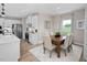 Dining area with light wood floors, a wood table and a view of the modern kitchen at 1024 Country Pasture Cv, Wendell, NC 27591