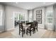 Bright dining room featuring a rustic wood table, elegant décor, and sliding glass doors to an outdoor patio at 1024 Country Pasture Cv, Wendell, NC 27591