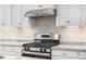 Stainless steel range and granite countertops in a white kitchen at 1024 Country Pasture Cv, Wendell, NC 27591