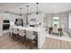 Modern kitchen features a large island with seating, stainless appliances, and adjacent dining area at 1024 Country Pasture Cv, Wendell, NC 27591