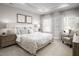 Serene bedroom featuring soft neutral tones, tray ceiling, plush bedding, and abundant natural light from large windows at 1024 Country Pasture Cv, Wendell, NC 27591