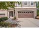 Townhome exterior featuring a brown garage door and walkway at 106 Park Manor Ln, Cary, NC 27519