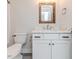 Bathroom featuring a white vanity with a marble countertop, a wooden-framed mirror and toilet at 120 Crosby Ln, Sanford, NC 27330