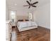 Cozy bedroom with hardwood floors, two windows, tufted headboard, and decorative nightstands at 120 Crosby Ln, Sanford, NC 27330