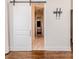 Stylish bedroom features a sliding barn door, hardwood floors, and modern fixtures at 120 Crosby Ln, Sanford, NC 27330