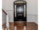 Welcoming entryway with dark hardwood floors, a paneled wall, and a decorative door at 120 Crosby Ln, Sanford, NC 27330