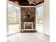 Cozy living space featuring a stone fireplace and large windows with scenic backyard views at 120 Crosby Ln, Sanford, NC 27330