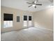 Spacious bedroom with carpet, ceiling fan, and double doors leading to a patio at 1673 Snowmass Way, Durham, NC 27713