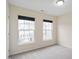 Bright bedroom with carpet, two large windows, and view of neighborhood at 1673 Snowmass Way, Durham, NC 27713