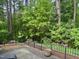 Backyard features landscaped flower beds, mature trees, and a wrought iron fence at 2112 White Pond Ct, Apex, NC 27523