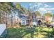 Two-story home with brick accents, an attached garage, a manicured lawn, and mature trees at 2112 White Pond Ct, Apex, NC 27523