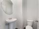 Clean powder room with pedestal sink and round mirror at 339 Suhani Ln, Clayton, NC 27520