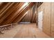 Unfinished attic space features exposed rafters and wood flooring at 3912 Cedar Knolls Dr, Youngsville, NC 27596