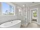 New bathroom with a soaking tub, walk-in glass shower, window with a view, and updated fixtures at 3912 Cedar Knolls Dr, Youngsville, NC 27596