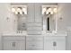 Double vanity sink in a modern bathroom with white cabinets, mirrors, and updated lighting fixtures at 3912 Cedar Knolls Dr, Youngsville, NC 27596