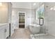Modern bathroom with a soaking tub, glass shower, and double vanity sinks with updated fixtures and tile floor at 3912 Cedar Knolls Dr, Youngsville, NC 27596