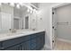 Bathroom showcasing double sink vanity with modern fixtures and a doorway leading to another room at 3912 Cedar Knolls Dr, Youngsville, NC 27596