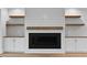 Elegant fireplace with white mantel, wood accents and built-in shelving with white cabinets and light hardwood floors at 3912 Cedar Knolls Dr, Youngsville, NC 27596