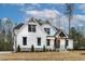 Stunning modern farmhouse with white siding, black windows, and a welcoming front porch at 3912 Cedar Knolls Dr, Youngsville, NC 27596